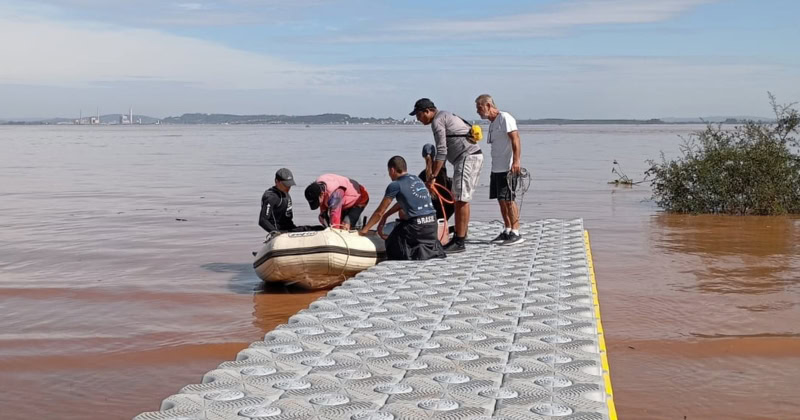 Voluntários em plataforma flutuante para auxiliar nos resgates das vítimas das enchentes